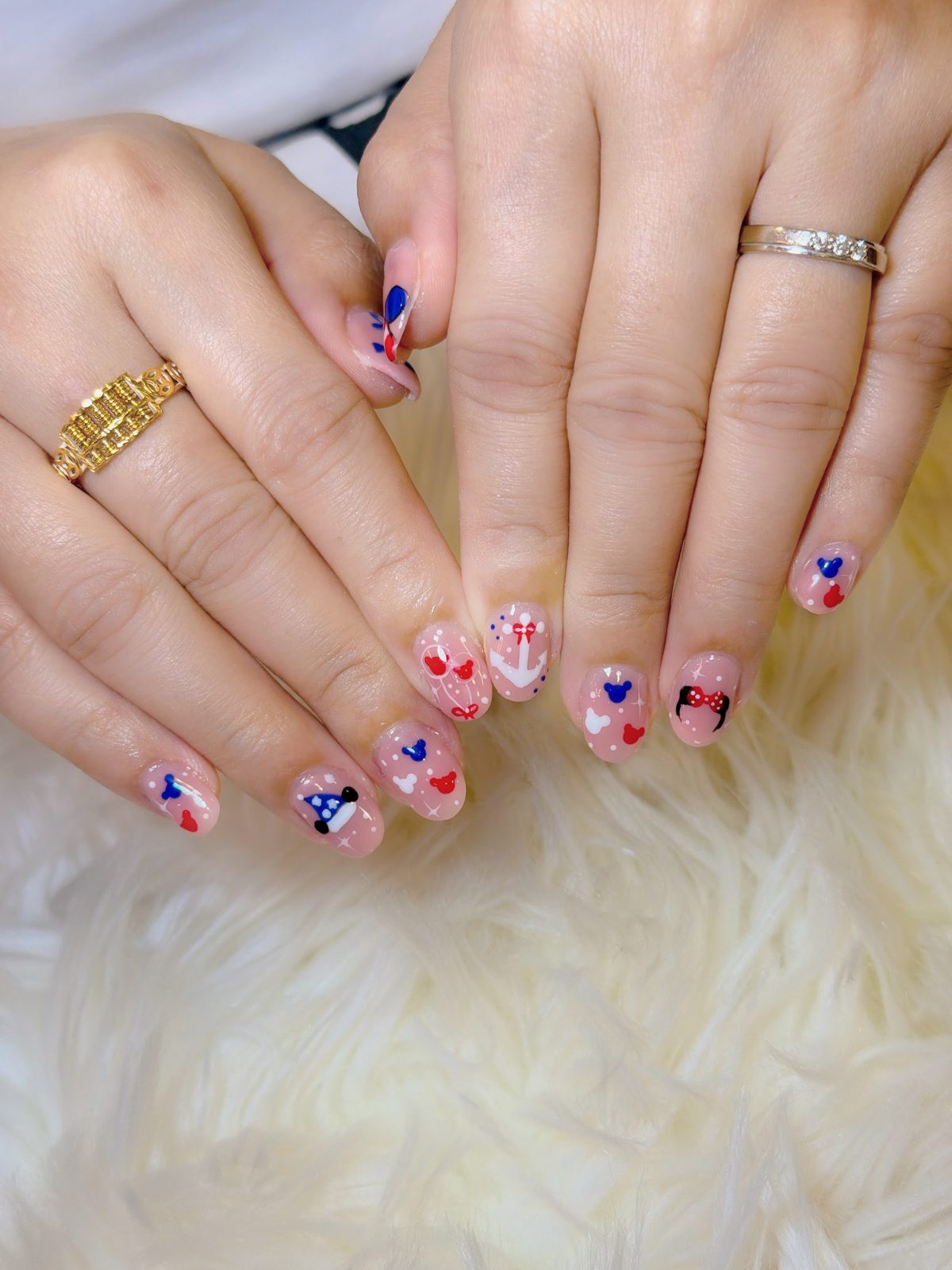 Two hands with hand-painted cherry and heart nail art